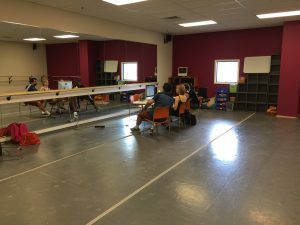 A group of people sitting in a dance studio.