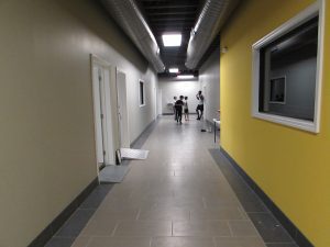 A hallway with two people walking down it.