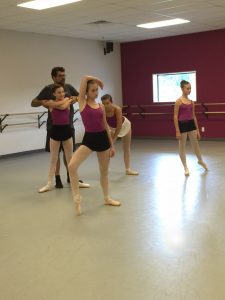 A group of dancers in a ballet class.