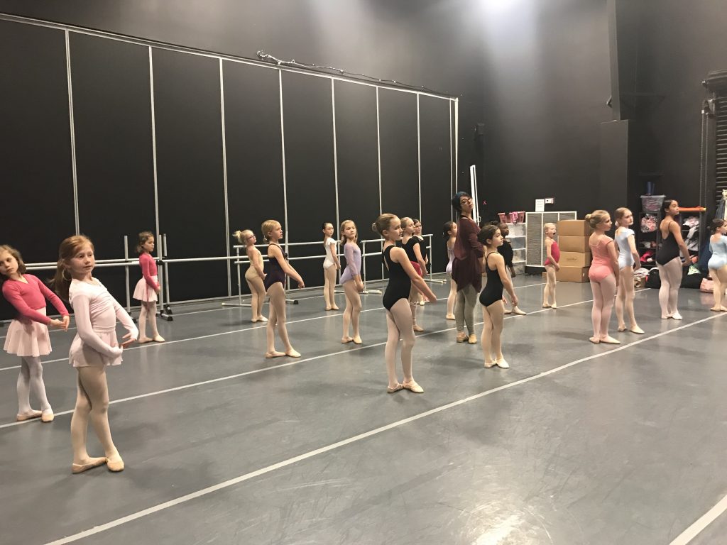 A group of young dancers in a dance studio.