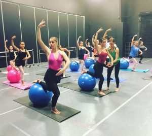 A group of dancers in a room with balls.