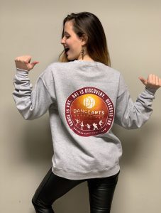 A woman wearing a sweatshirt with the word dance on it.