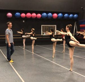 A group of dancers in a ballet class.