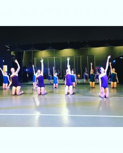 A group of dancers in a dance studio.